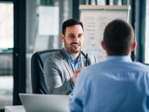 Two men in a professional setting having a pleasant meeting, lender and business owner discussing invoice financing