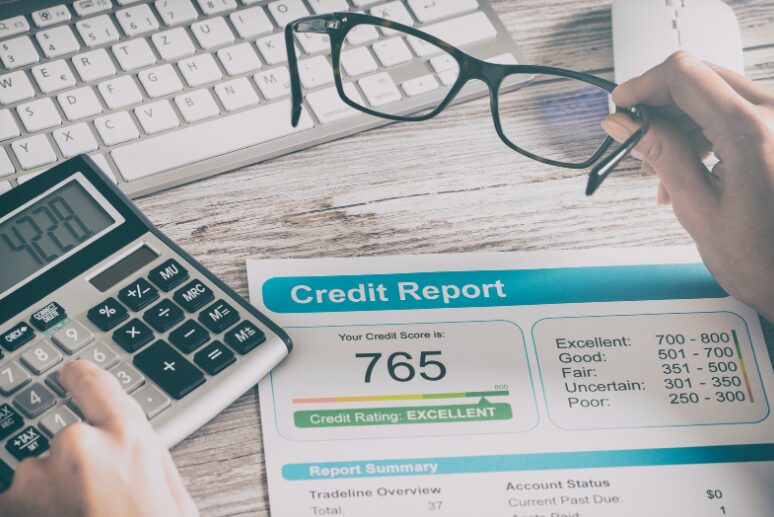 Financial lender with glasses using a calculator to assess a credit score, analysing options for an unsecured business overdraft vs secured business overdraft.