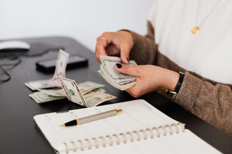 A lender counting money, representing reliable cash flow loan options for businesses, including cash flow lending in Melbourne.