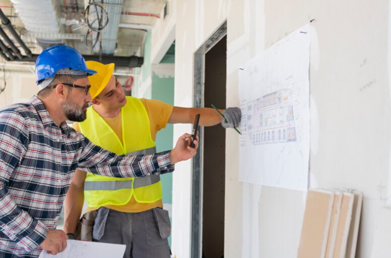 Two men refurbishing an office space, demonstrating the need for fitout finance qualifications to cover essential upgrades.