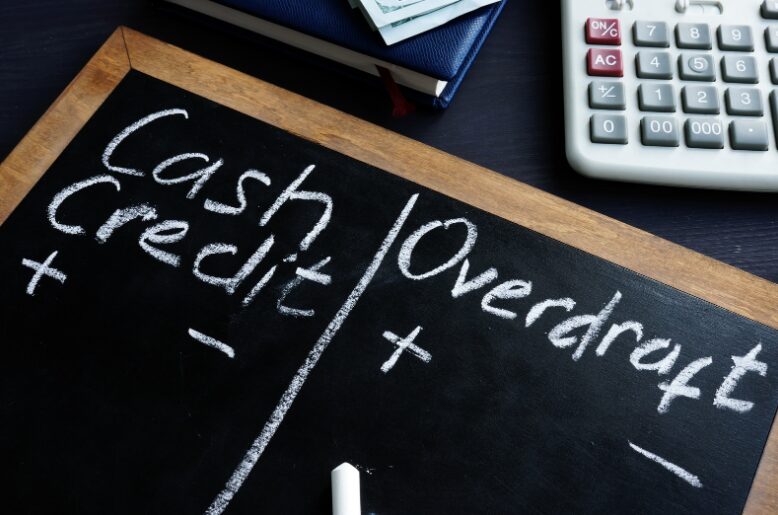 A board with 'Cash Credit' and 'Overdraft' written in chalk, illustrating the financial decision between unsecured business overdraft vs secured business overdraft.