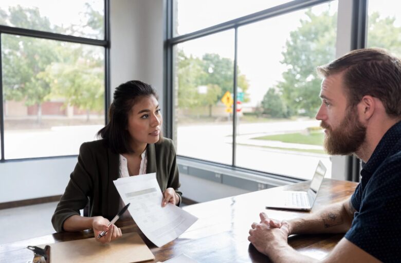 Loan officer checking a customer’s application to ensure a safe tax debt loan, helping them avoid tax debt loan scams and financial risks.