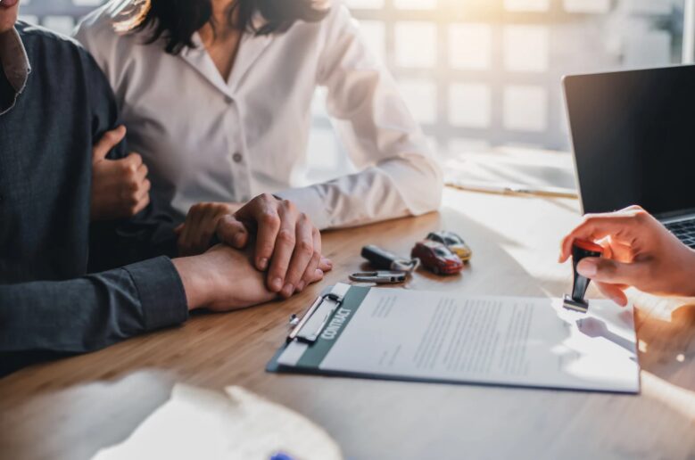 Happy couple with a banker approving a tax debt loan, relieved after securing a safe financial solution to avoid tax debt loan scams.