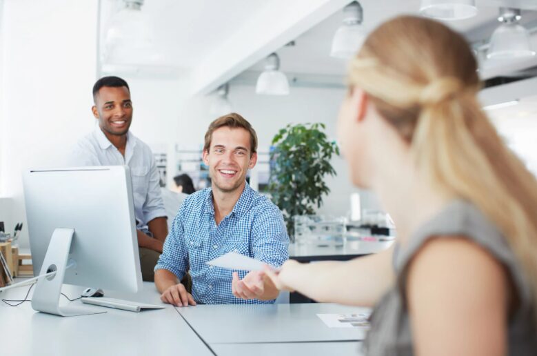 Bank professional smiling while receiving a note from a business client, discussing types of working capital funding for cash flow management.