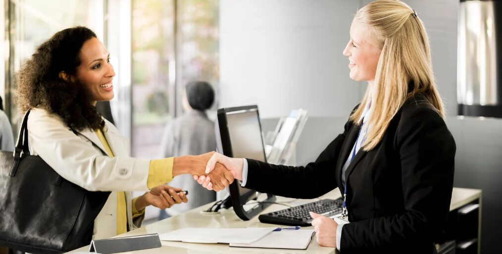 Female business owner and non-bank lender smiling while shaking hands, discussing bank vs non bank lenders for working capital financing.