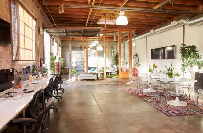 Spacious empty office with modern tables and chairs, well-lit—showcasing the potential of fitout financing in Australia to create a functional workspace.