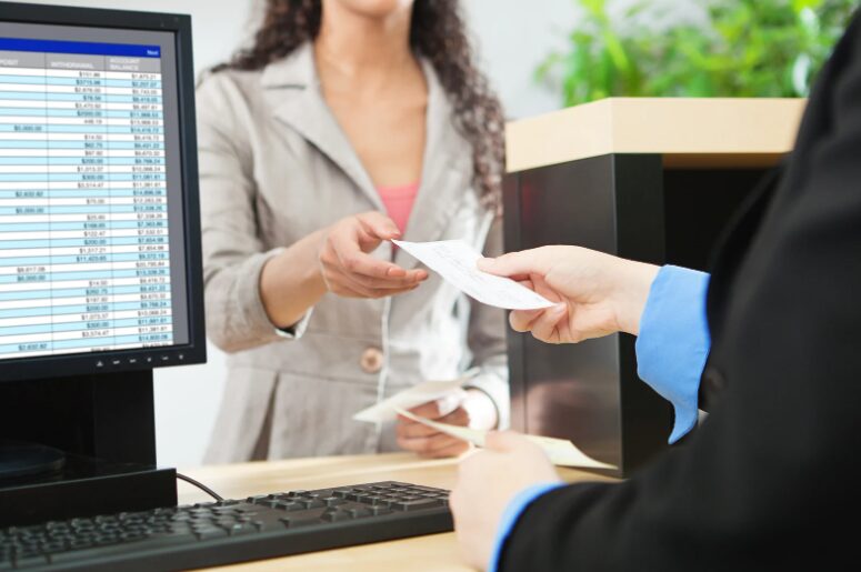 Financial broker handing a note to a business owner, discussing types of working capital funding for cash flow and growth solutions.