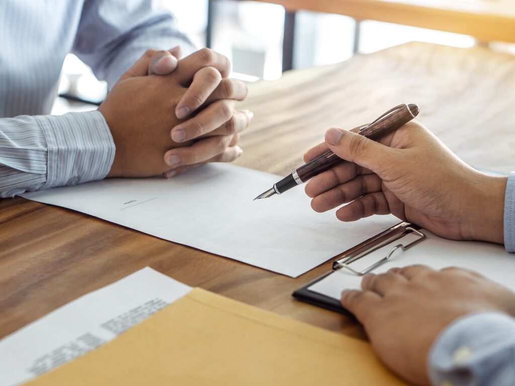 Cropped photo of two men showing only their hands, two men in the middle of signing a contract, signing a loan agreement for a working capital loan