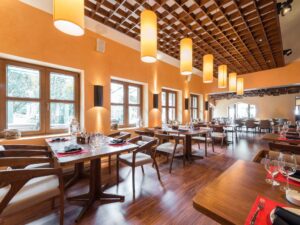 Warm woodsy interior of a restaurant with plenty of warm lighting and rows of cozy dining tables and chairs, interior design made possible with fitout finance