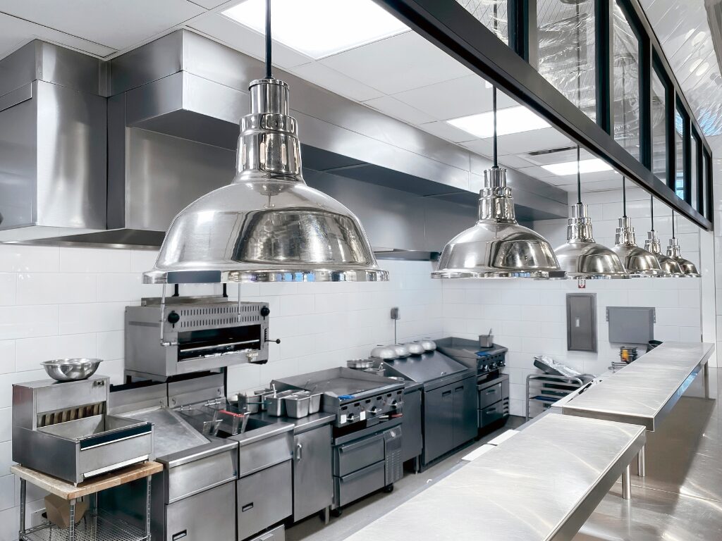 All-stainless steel industrial kitchen set-up, specialised equipment like griddle, oven, stove, and fryers purchased through equipment finance