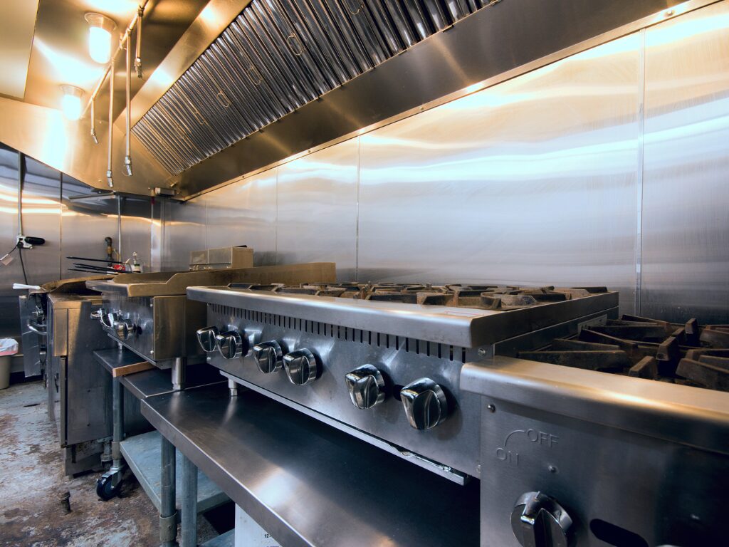 A closer, angled photo of a row of industrial stovetops, a stainless steel industrial kitchen funded with business equipment finance