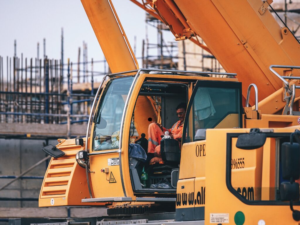 Crane operator inside a crane, working on a construction site, large equipment funded by bad credit equipment finance in Australia