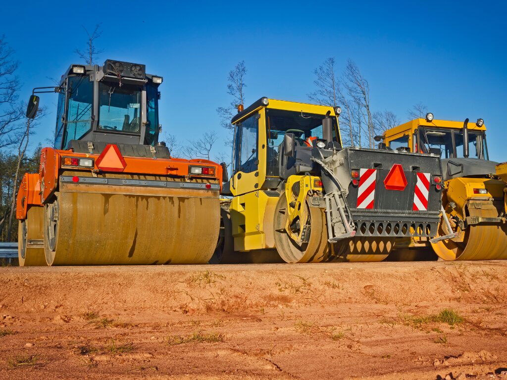 A row of three heavy wheeled machinery, roller compactor, road rollers for construction and industrial works