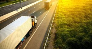 White truck with a container on a highway, focusing on transportation & truck financing for businesses securing truck and trailer loans.