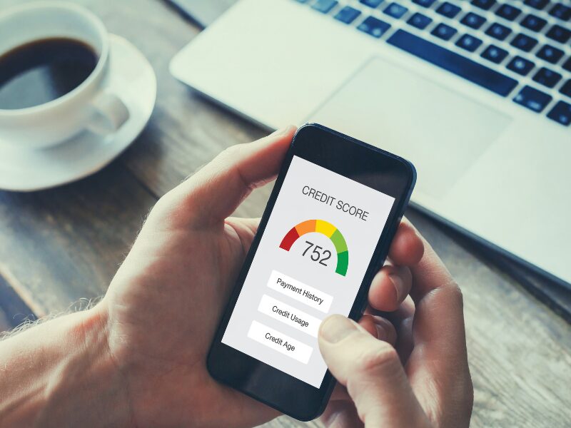 A man holding his smartphone, phone displaying the man’s credit score of 752