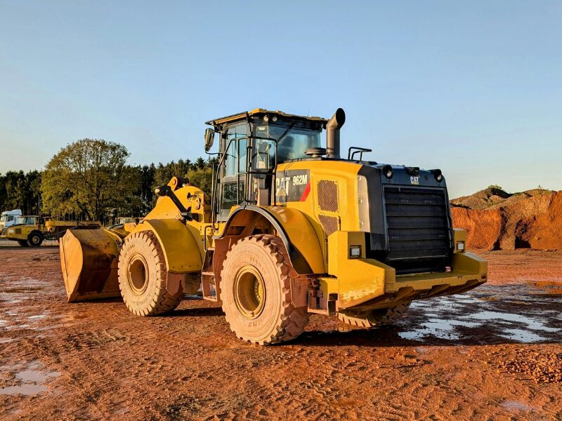 Large yellow equipment for construction and industrial works, heavy equipment driving over reddish soil