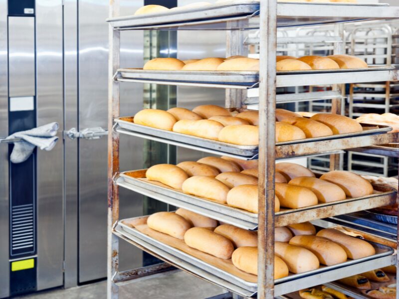Racks of bread rolls ready to be baked in an industrial oven
