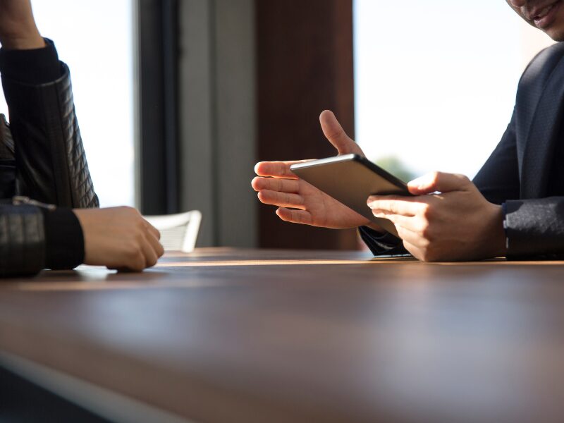 Cropped photo of a lender or lending professional explaining loan terms to a borrower, man holding a tablet explaining terms to a borrower
