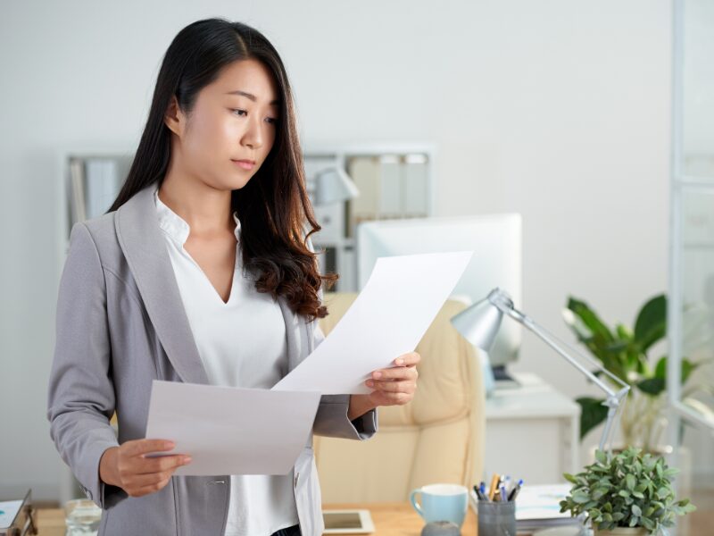 A woman reviews two documents, choosing between equipment finance and overdrafts for equipment purchases