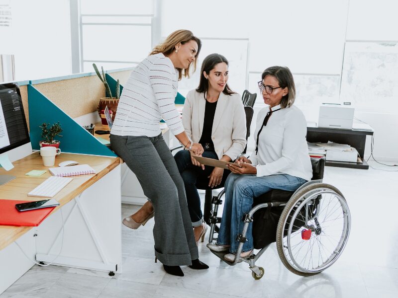 Two NDIS providers speak with a woman with a disability, three women in discussion