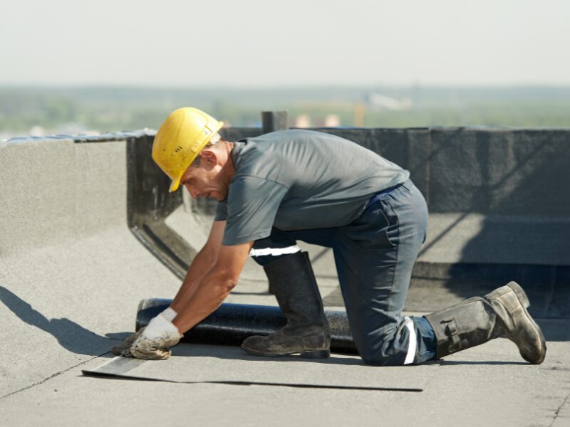 Labourer working on the rooftop of a commercial property