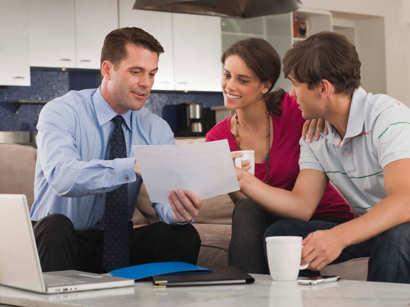 A financial planner shows a document to clients during a financial advisory meeting