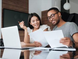 A man and a woman in a discussion while reading documents, home buyers discussing which repayment schedule to follow for their loan