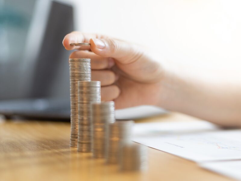 A hand stacking coins in ascending order, concept photo for interest savings from switching repayment schedule