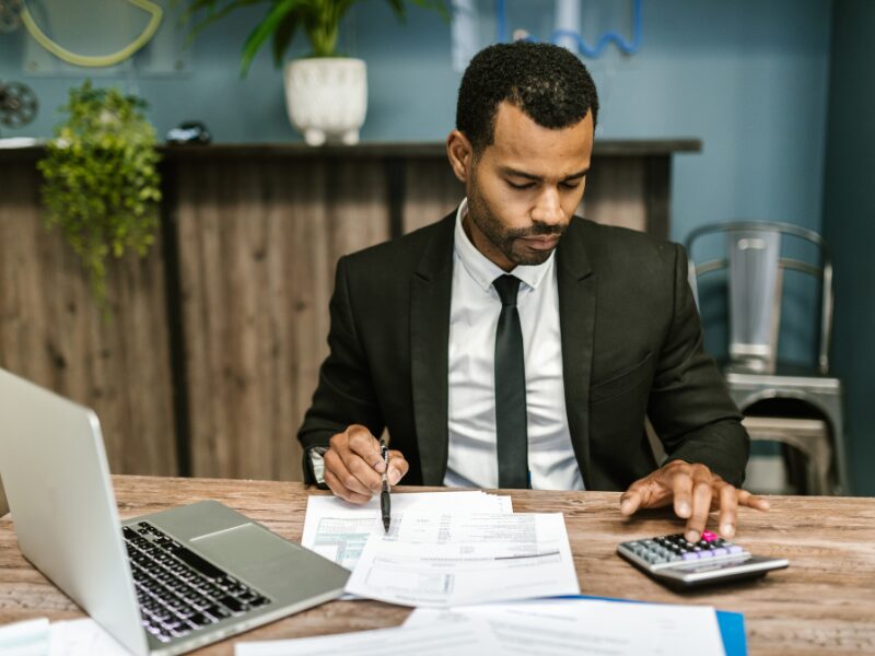 A business owner calculates tax debts and interest charges to prepare for deductibility changes