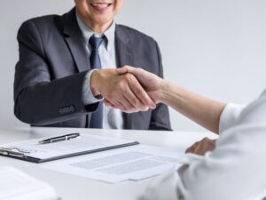 A loan broker and a client shake hands after agreeing on a tax debt loan solution to pay off ATO tax obligations