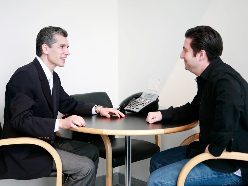 A business owner meeting with a finance broker to talk about tax debt loans ahead of ATO tax deductibility changes