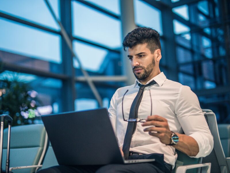 A man takes off his glasses as he uses his laptop, Australian business owner reading about the upcoming tax interest deductibility changes