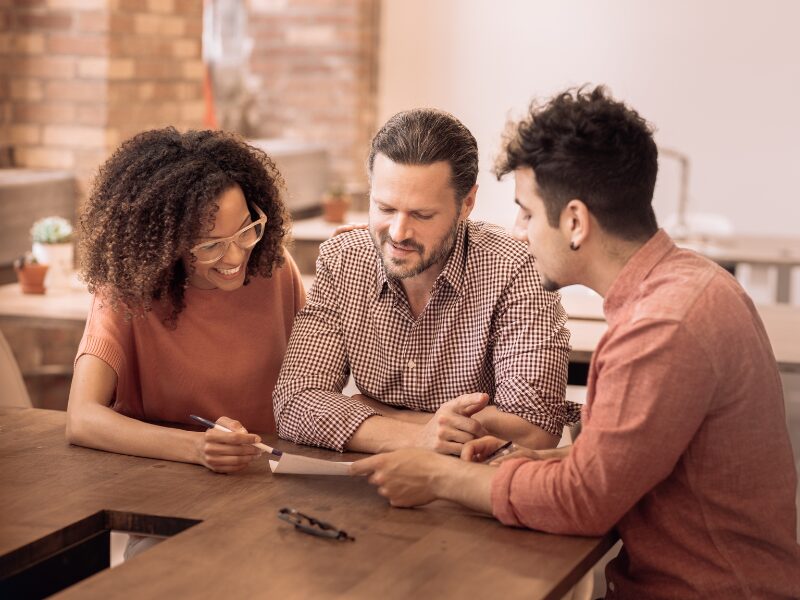 A mortgage broker or lender shows business owners the benefits of tax debt loans as a way to pay off tax debts before interest deductibility changes are implemented