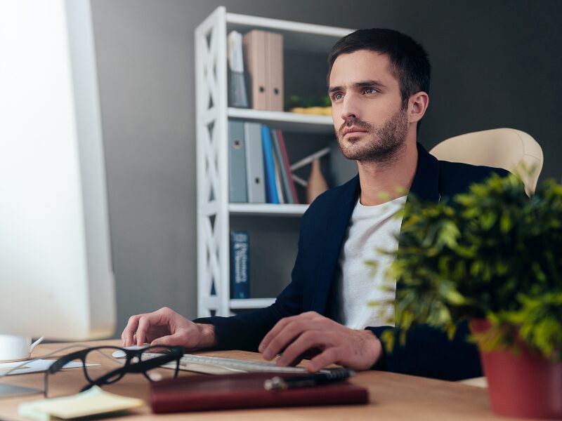 A man in his office uses his computer to read about the ATO interest deductibility changes
