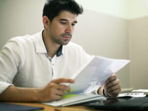 A man reads a document, an investor looking at his loan statements to see how much interest he’s paying on an investment property