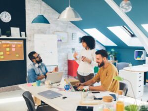 Three people working on their startup at an office, startup business owners talking about quick funding