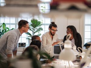 A group of peers in a happy discussion in an office, people in a startup talking about approved funding options