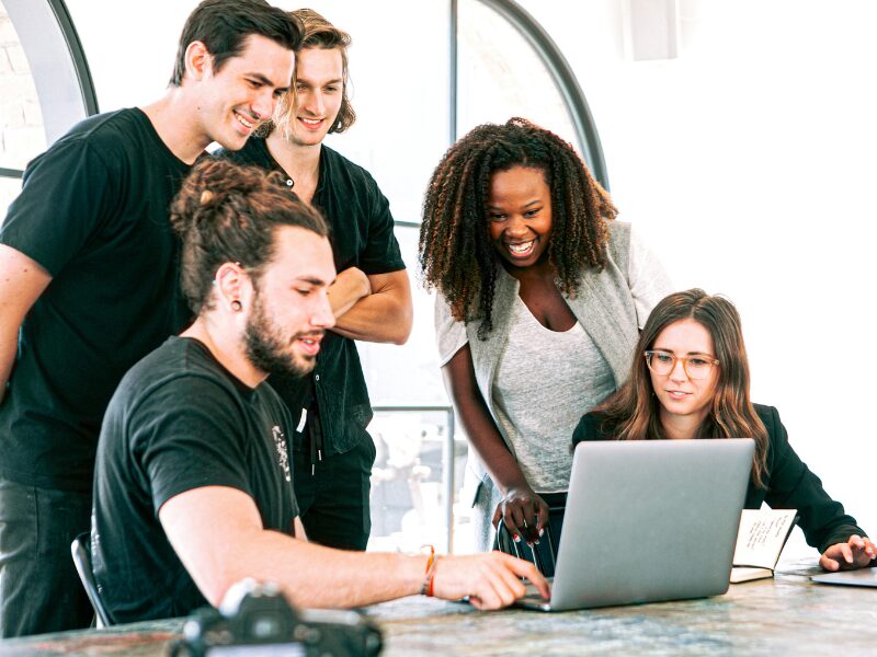 People working at a startup looking at the screen of a laptop during a meeting