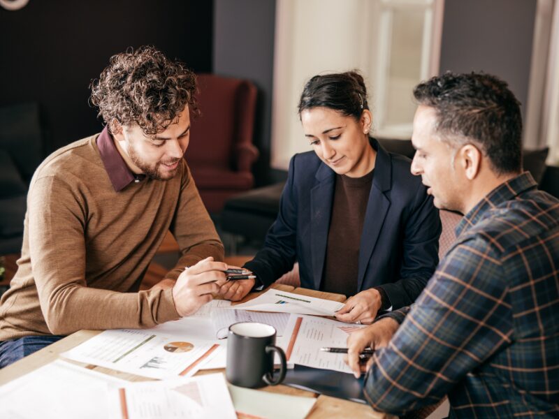 Business owners talking to a lending professional regarding refinancing a business loan
