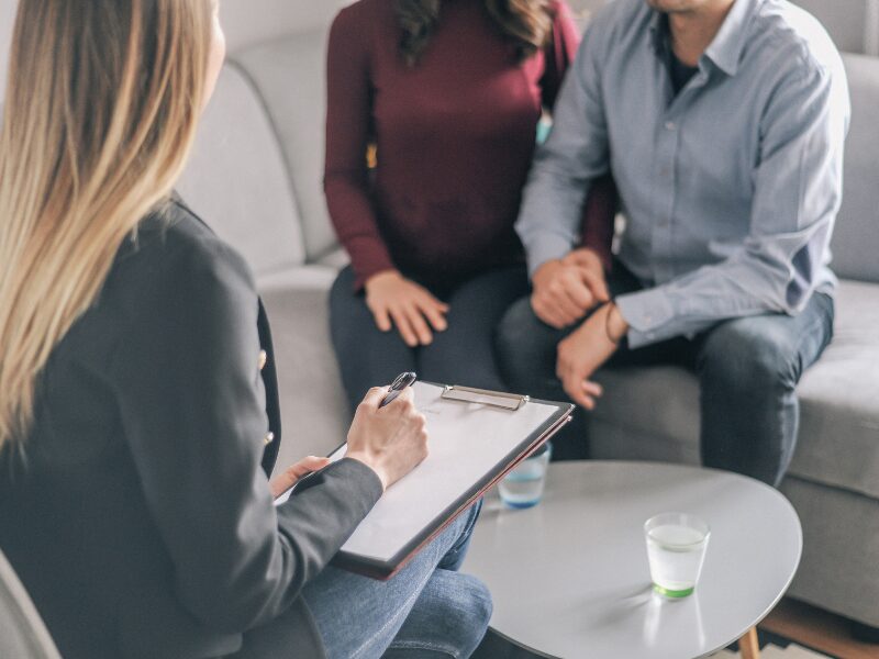 A business-owning couple meet with a mortgage broker to discuss refinancing an unsecured loan with the right lender