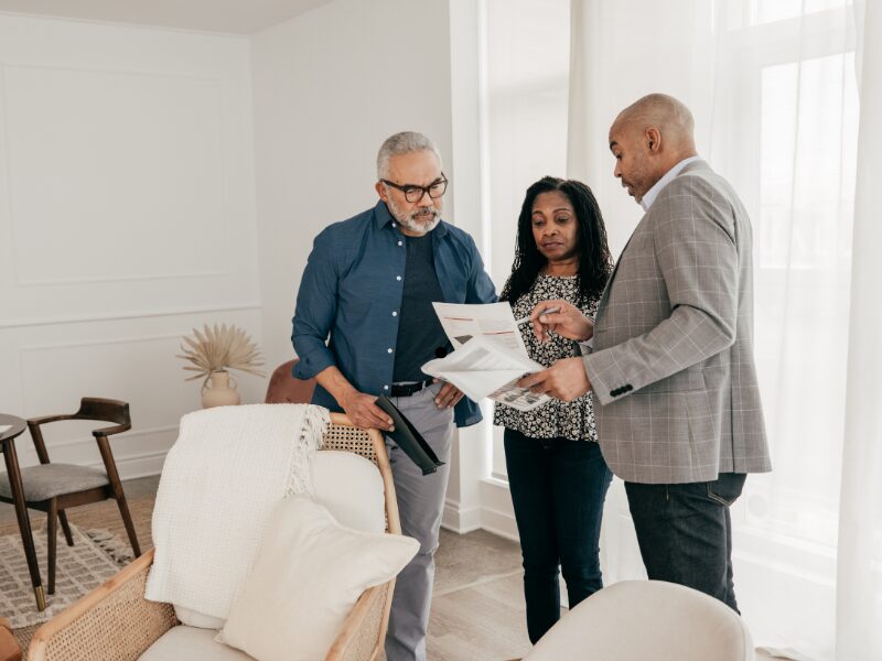 A mortgage broker points to a document and discusses the requirements for a self employed home loan with clients