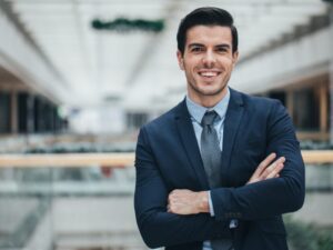 Confident businessman in a suit with his arms crossed smiling at camera