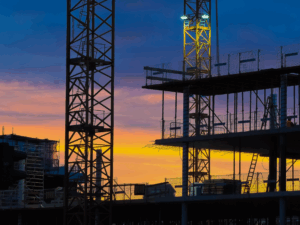 Silhouette of an ongoing construction of a building against the dusk sky
