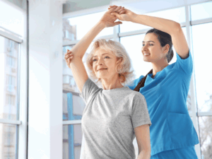 A physiotherapist happily assisting a patient with arm stretches