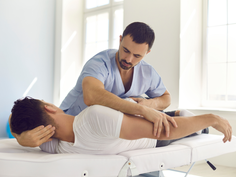 A physiotherapist assisting a client with body stretches