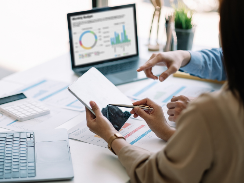 Small business owners undergoing restructuring going through their finances, using an electronic tablet to go over finances