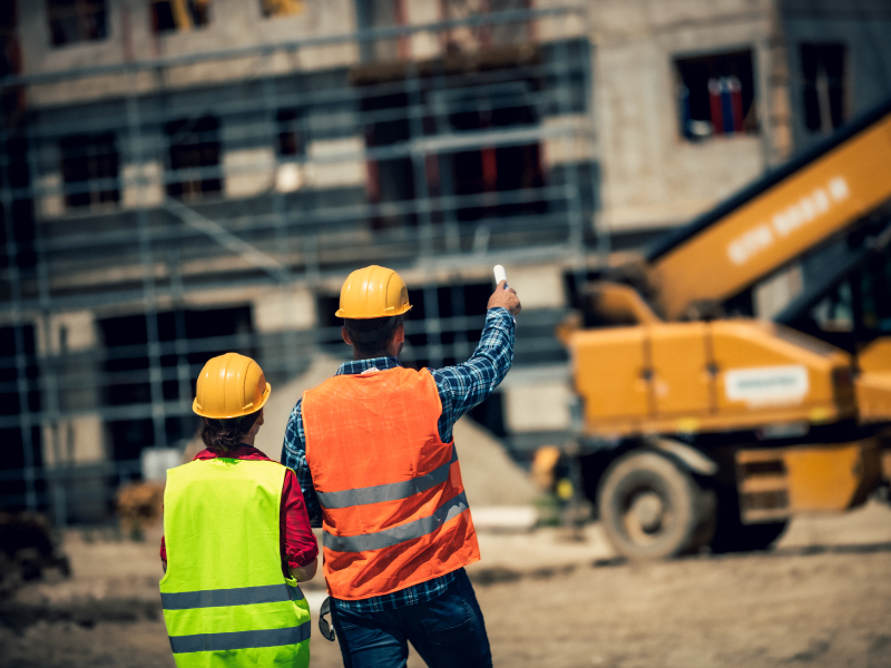 Contractors in safety gear examining an ongoing construction project