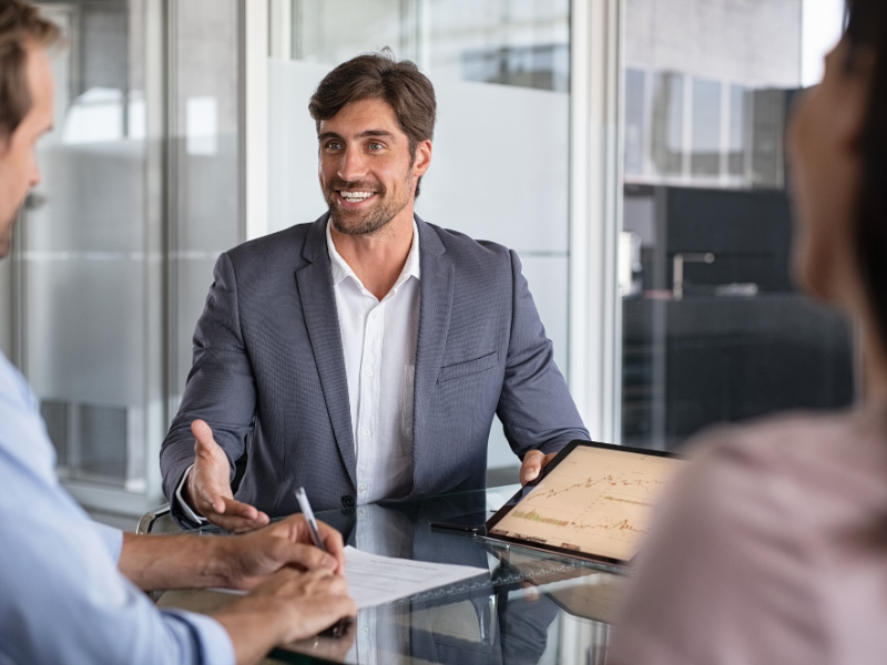 A mortgage broker happily discusses details of a low doc loan to self-employed borrowers