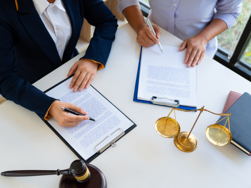 A declarant and a witness sign a statutory declaration in person, a judge’s gavel and law scales placed on the table