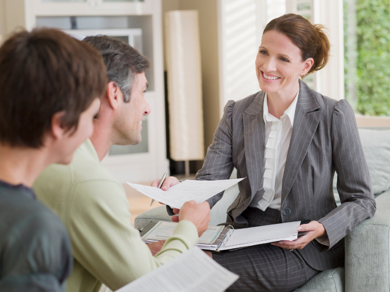 A mortgage broker in a meeting with two clients, discussing a low doc refinance